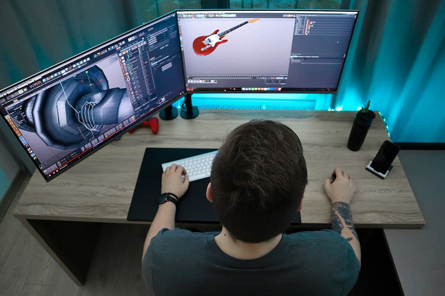 Persona modella un pezzo meccanico e una chitarra su software 3D.